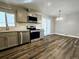 Updated kitchen with stainless steel appliances, gray cabinetry, and adjacent dining area at 6717 Lee St, Arvada, CO 80004