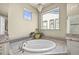Spa-like bathroom showcasing a soaking tub, picture window, and elegant chandelier for a relaxing ambiance at 15033 Delhi Ave, Parker, CO 80134