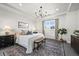 Bright bedroom featuring a large bed, bench, chandelier, and ample natural light for a relaxing retreat at 15033 Delhi Ave, Parker, CO 80134