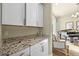 Features stylish cabinetry and a granite countertop, seamlessly connecting to a room with a piano at 15033 Delhi Ave, Parker, CO 80134