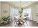 Bright dining room features a round table, hardwood floors, modern chandelier, and many windows at 15033 Delhi Ave, Parker, CO 80134