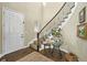 Elegant foyer featuring a curved staircase with iron railings and hardwood flooring, complemented by stylish decor at 15033 Delhi Ave, Parker, CO 80134