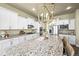 Open kitchen with granite counters, an island with seating, stainless steel appliances, and white cabinetry at 15033 Delhi Ave, Parker, CO 80134