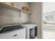 Convenient laundry room showcasing modern washer and dryer units adjacent to a bright bathroom at 15033 Delhi Ave, Parker, CO 80134