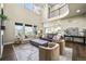 Open-concept living room with high ceilings, chandelier, and hardwood flooring, showcasing seamless flow to kitchen at 15033 Delhi Ave, Parker, CO 80134