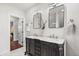 This bathroom features double sinks with a marble countertop and views into the primary bedroom at 1832 W 36Th Ave, Denver, CO 80211