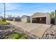 View of detached garages, a long driveway, and desert-style landscaping in the front at 1832 W 36Th Ave, Denver, CO 80211
