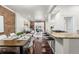 Open-concept dining and living space featuring a breakfast bar, hardwood floors, and brick wall at 1832 W 36Th Ave, Denver, CO 80211