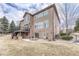 Back exterior showcasing patio, balcony, fire pit and lush backyard at 9315 E Aspen Hill Ln, Lone Tree, CO 80124