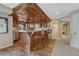 Basement features a built-in bar area, a beverage refrigerator, and a seating area with four barstools at 9315 E Aspen Hill Ln, Lone Tree, CO 80124