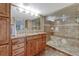 Bathroom with granite counters, custom cabinets, and glass enclosed shower with bench at 9315 E Aspen Hill Ln, Lone Tree, CO 80124