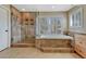Updated Primary bathroom with large soaking tub, separate shower, and shuttered windows at 9315 E Aspen Hill Ln, Lone Tree, CO 80124