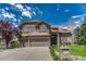 Handsome two-story home featuring a well-manicured lawn and a three-car garage, perfect for Gathering living at 9315 E Aspen Hill Ln, Lone Tree, CO 80124