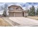 Two-story home featuring a well-manicured lawn, stone accents, and a three-car garage at 9315 E Aspen Hill Ln, Lone Tree, CO 80124