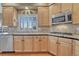 Bright kitchen with stainless steel appliances, granite counters, tile backsplash, and a window with shutters at 9315 E Aspen Hill Ln, Lone Tree, CO 80124
