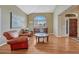 Inviting living room with hardwood floors, arched windows, and leather chairs at 9315 E Aspen Hill Ln, Lone Tree, CO 80124