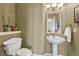 Stylish powder room featuring a pedestal sink, decorative mirror, and modern lighting at 9315 E Aspen Hill Ln, Lone Tree, CO 80124