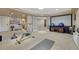This workout room features exercise equipment, a large screen, and lots of natural light at 9315 E Aspen Hill Ln, Lone Tree, CO 80124