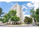 Bright exterior shot of a tall building with multiple stories, balconies and beautiful trees nearby at 1200 N Humboldt St # 1204, Denver, CO 80218