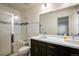 Bathroom featuring double sinks, a large mirror, and a shower with glass door at 13725 Ash Cir, Thornton, CO 80602