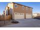 Exterior view of a two car garage on a tan home with updated doors at 13725 Ash Cir, Thornton, CO 80602