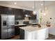 Modern kitchen with stainless steel appliances, dark cabinets, and a center island with quartz countertop at 13725 Ash Cir, Thornton, CO 80602