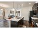 Modern kitchen featuring a center island, stainless steel appliances, dark cabinetry, and pendant lighting at 13725 Ash Cir, Thornton, CO 80602