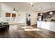 Open-concept living area with hardwood floors connecting the living room, kitchen, and dining space at 13725 Ash Cir, Thornton, CO 80602