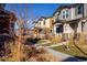 A row of well-kept townhomes with inviting front porches and manicured landscaping along a sidewalk at 13725 Ash Cir, Thornton, CO 80602