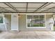 Front porch entrance with a white security door, concrete patio, and large picture window at 4155 S Lipan St, Englewood, CO 80110