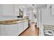Well-lit kitchen with white cabinets, granite counters, stainless steel appliances, and hardwood flooring at 4155 S Lipan St, Englewood, CO 80110