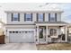 Charming two-story home with gray siding, black shutters, a two-car garage, and a cozy front porch at 11866 High Desert Rd, Parker, CO 80134