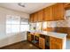 Kitchen with wood cabinets, vinyl floor, and a large window at 1490 S Glencoe St, Denver, CO 80222