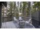 Outdoor deck with chairs, a fire pit, and views of surrounding trees at 236 Harris Dr, Idaho Springs, CO 80452