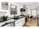 Modern kitchen features black granite countertops, white cabinets, and dining area at 236 Harris Dr, Idaho Springs, CO 80452