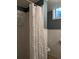 The basement bathroom features a shower with a ruffled curtain, and white wainscotting at 1500 S Perry St, Denver, CO 80219