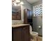 This bathroom offers a single sink vanity, toilet, and window with dark brown accents at 1500 S Perry St, Denver, CO 80219