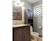 This bathroom features a vanity, toilet, dark brown accents, and a mirror over the sink at 1500 S Perry St, Denver, CO 80219