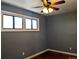 Bedroom featuring two windows, ceiling fan, and hardwood flooring at 1500 S Perry St, Denver, CO 80219