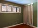This bedroom features olive colored walls, a window, and a closet with neutral colored curtain doors at 1500 S Perry St, Denver, CO 80219
