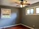Bedroom with ceiling fan, two windows with natural light and hardwood flooring at 1500 S Perry St, Denver, CO 80219