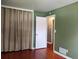 Bedroom with hardwood flooring, neutral wall color, and a door leading to another room at 1500 S Perry St, Denver, CO 80219