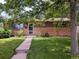 Inviting brick home featuring a lush green lawn and a tidy walkway to the entrance at 1500 S Perry St, Denver, CO 80219