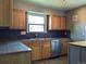 Well-equipped kitchen with wooden cabinets, granite countertops, and stainless steel appliances at 1500 S Perry St, Denver, CO 80219