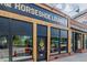 Horseshoe Lounge entrance with rustic wood trim, black trim, and string lights, reflecting the outside through the windows at 1975 N Grant St # 509, Denver, CO 80203