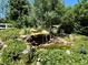 Private backyard oasis featuring a waterfall, pond, and lush, mature landscaping at 12705 Kalamath Ct, Westminster, CO 80234