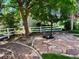 Stone patio area in a backyard with mature trees and a white fence at 12705 Kalamath Ct, Westminster, CO 80234