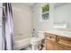 Bathroom with tub and shower, light gray walls, and a wood-look vanity with a sink and toilet at 12705 Kalamath Ct, Westminster, CO 80234