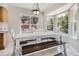 Breakfast nook featuring large windows with backyard views, pendant lighting, and rustic dining set at 12705 Kalamath Ct, Westminster, CO 80234