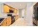 Efficient kitchen with light wood cabinets, black appliances, and tile backsplash at 12705 Kalamath Ct, Westminster, CO 80234